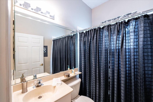 bathroom featuring a shower with shower curtain, vanity, and toilet