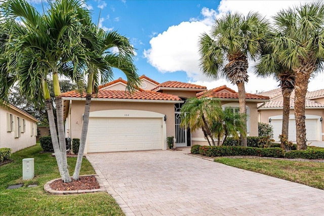 mediterranean / spanish-style house featuring a garage and a front lawn