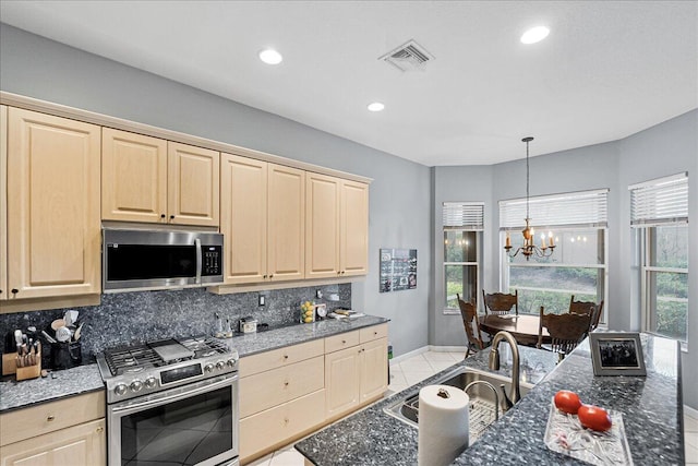 kitchen featuring decorative backsplash, stainless steel appliances, decorative light fixtures, and an inviting chandelier