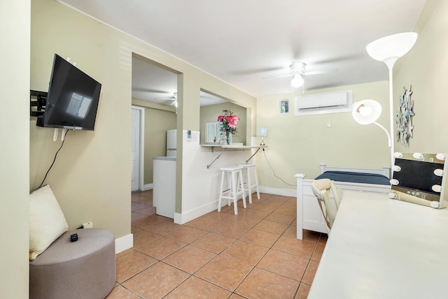 interior space featuring white fridge, a wall unit AC, ceiling fan, and light tile patterned flooring