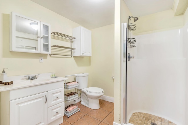 bathroom with tile patterned floors, vanity, toilet, and walk in shower