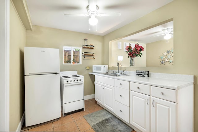 kitchen with white appliances, ceiling fan, sink, light tile patterned floors, and white cabinetry