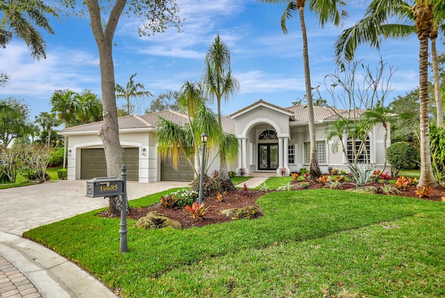 view of front of house with french doors, a garage, and a front lawn