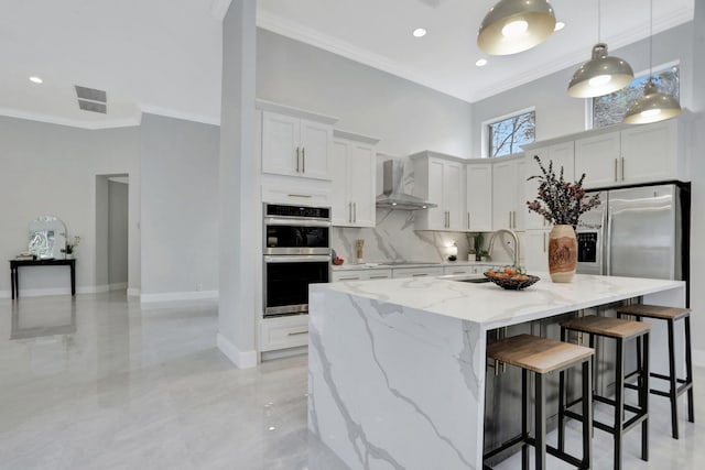 kitchen featuring sink, wall chimney exhaust hood, a center island with sink, white cabinets, and appliances with stainless steel finishes