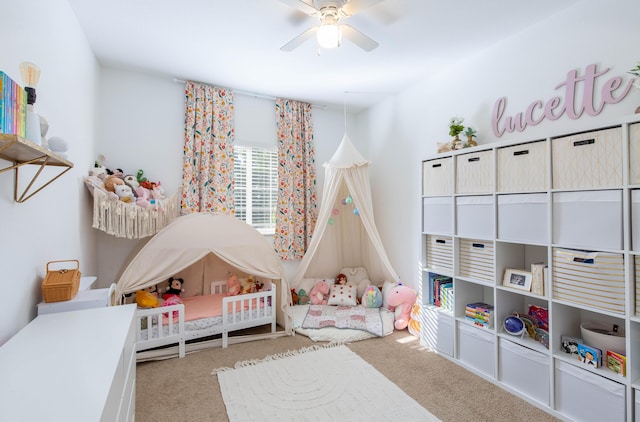 carpeted bedroom featuring a crib and ceiling fan