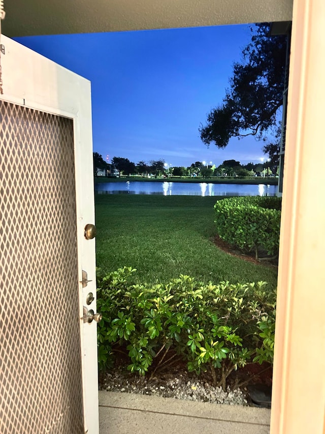 yard at dusk featuring a water view