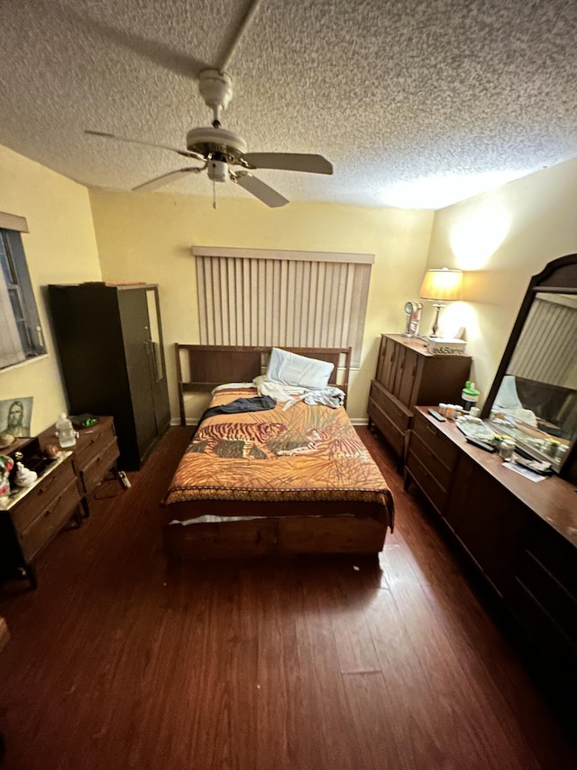 bedroom with ceiling fan, dark hardwood / wood-style floors, and a textured ceiling