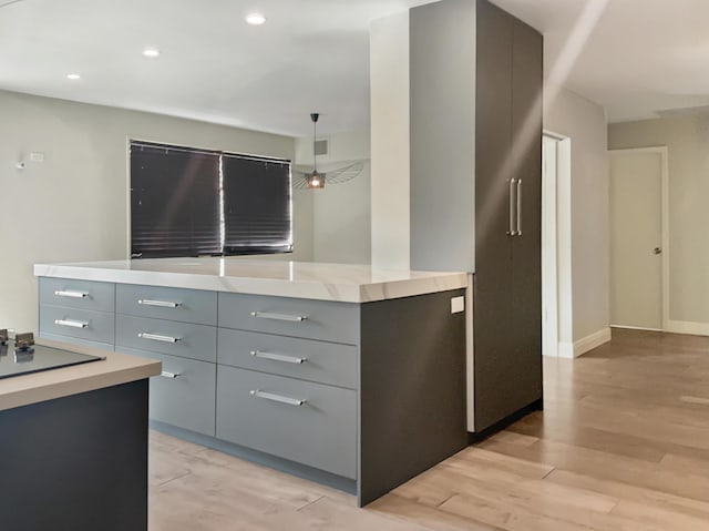 kitchen with gray cabinetry, black electric cooktop, light hardwood / wood-style floors, and decorative light fixtures