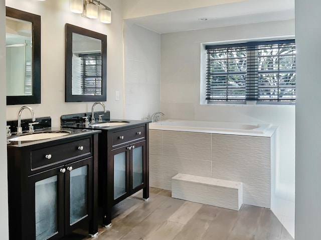 bathroom with vanity and a relaxing tiled tub