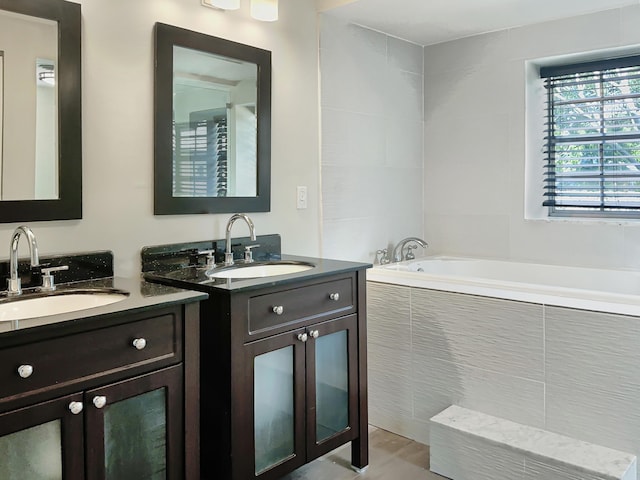 bathroom featuring vanity and tiled bath