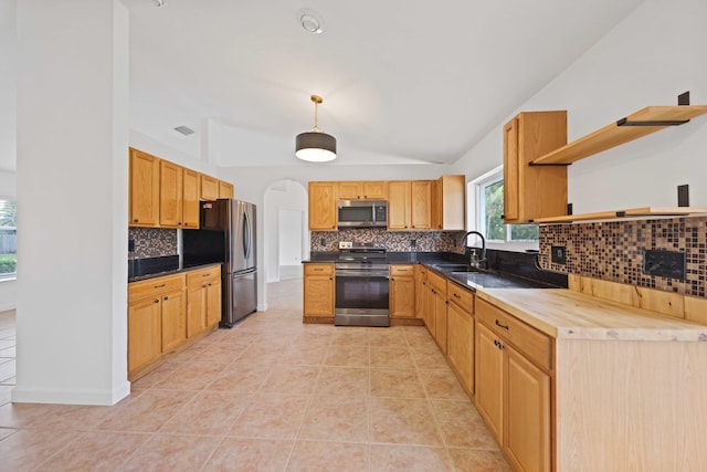 kitchen with sink, hanging light fixtures, butcher block countertops, light tile patterned floors, and appliances with stainless steel finishes