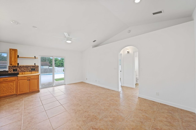 unfurnished living room featuring ceiling fan, light tile patterned floors, and lofted ceiling