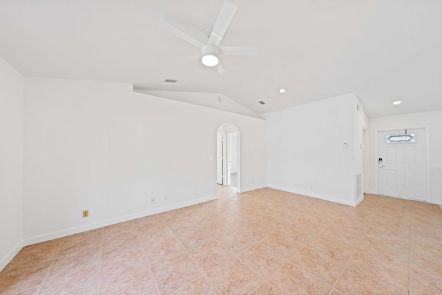 empty room with vaulted ceiling, ceiling fan, and light tile patterned flooring