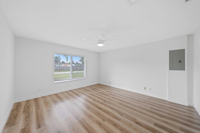 spare room with electric panel, light hardwood / wood-style flooring, and ceiling fan