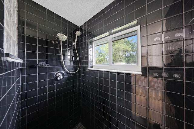 bathroom featuring a tile shower and a textured ceiling