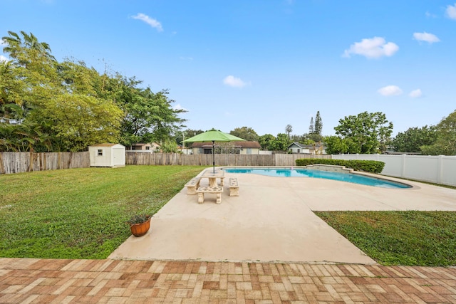 view of pool with a storage unit, a patio area, and a yard