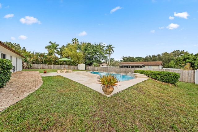 view of yard with a fenced in pool, a patio area, and a storage shed