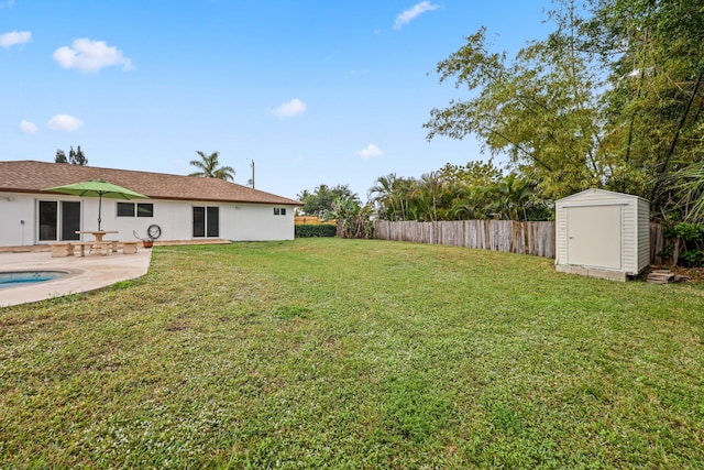 view of yard with a shed, a fenced in pool, and a patio