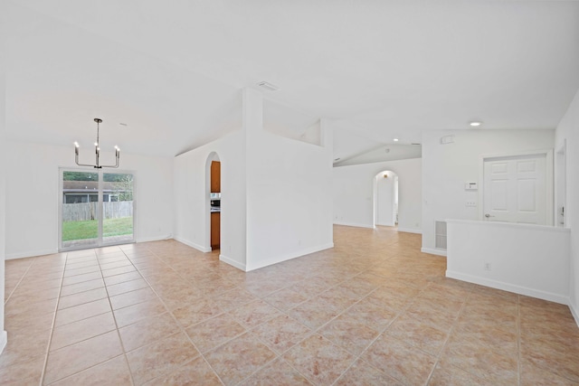 unfurnished living room with a chandelier, light tile patterned floors, and vaulted ceiling