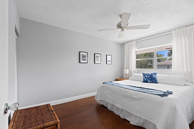 bedroom featuring a textured ceiling, dark hardwood / wood-style flooring, and ceiling fan