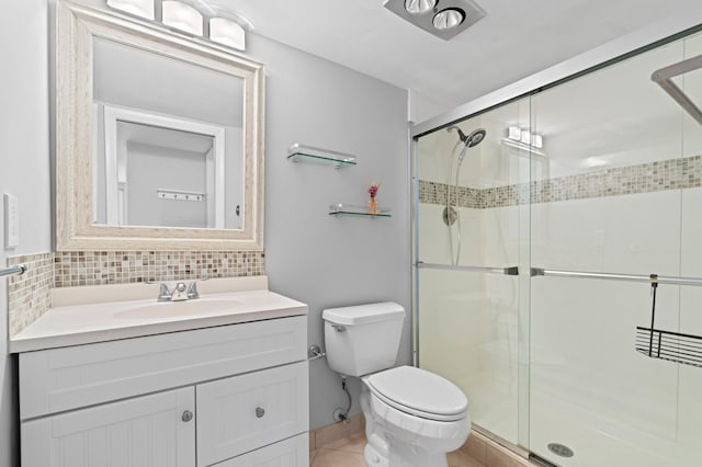 bathroom with decorative backsplash, vanity, toilet, and a shower with shower door