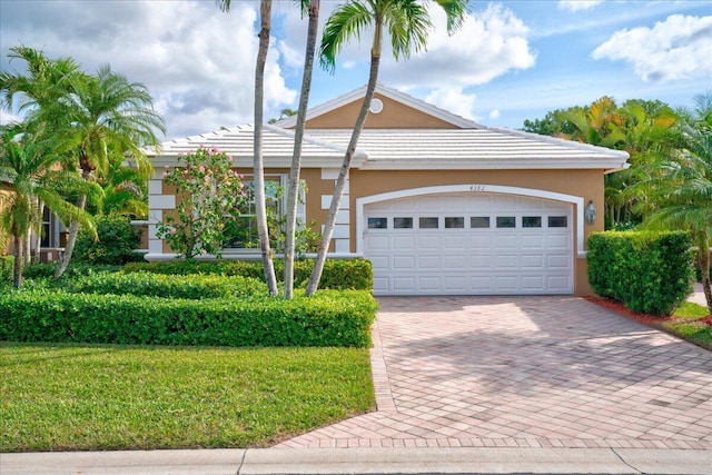 ranch-style house with a garage and a front lawn