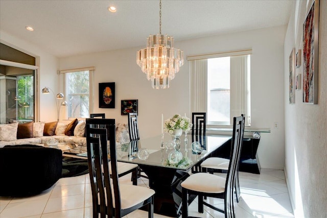 dining room featuring a textured ceiling, an inviting chandelier, and light tile patterned flooring