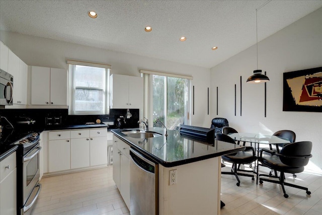 kitchen featuring sink, white cabinetry, an island with sink, and appliances with stainless steel finishes