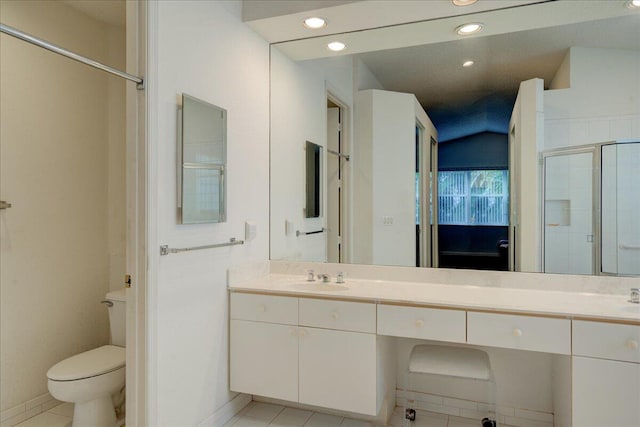 bathroom with tile patterned floors, vanity, toilet, and a shower with door