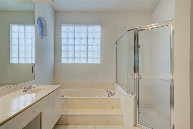 bathroom with a textured ceiling, vanity, shower with separate bathtub, and a wealth of natural light