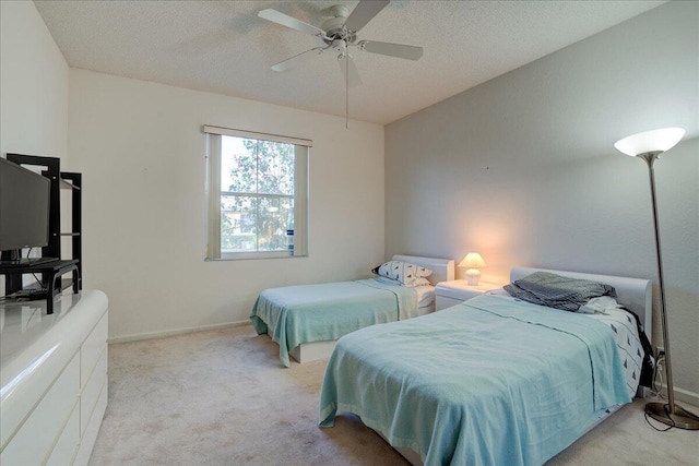 bedroom featuring ceiling fan, light colored carpet, and a textured ceiling