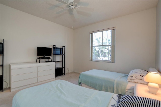 bedroom with ceiling fan, light carpet, and a textured ceiling