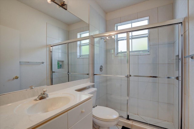 bathroom featuring vanity, an enclosed shower, and toilet