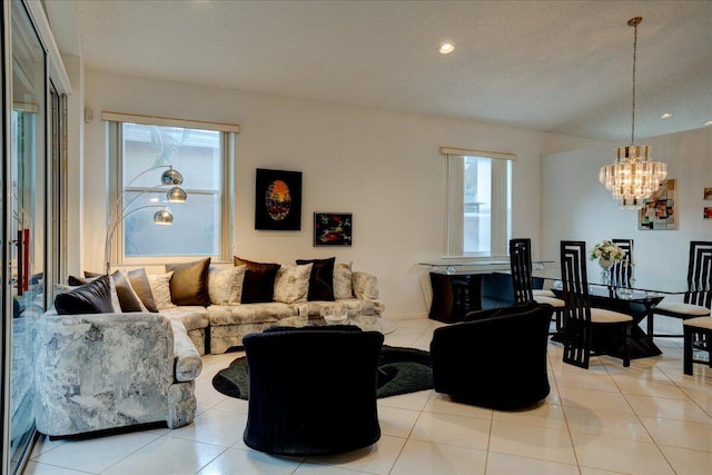 living room featuring a notable chandelier, light tile patterned flooring, and a textured ceiling