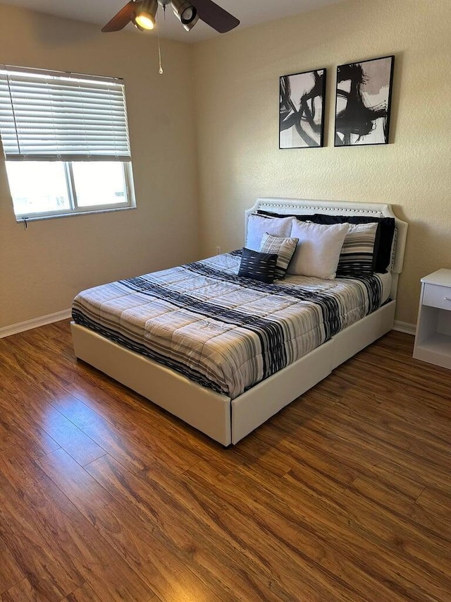 bedroom with ceiling fan and dark wood-type flooring