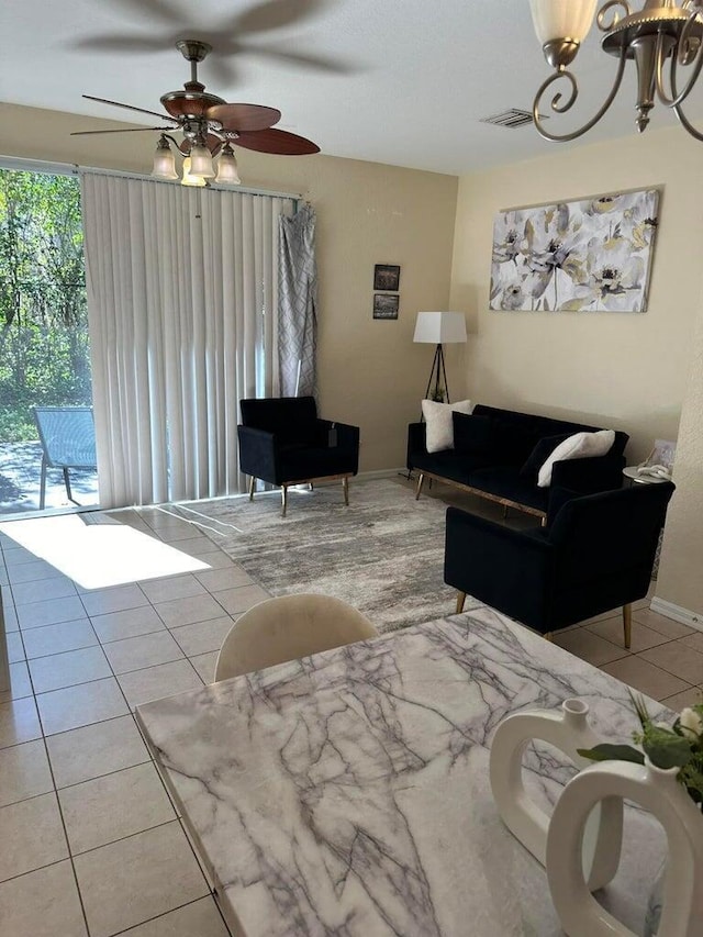 living room with ceiling fan with notable chandelier and light tile patterned flooring