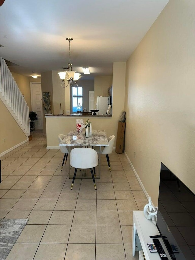 dining space featuring light tile patterned floors and a notable chandelier