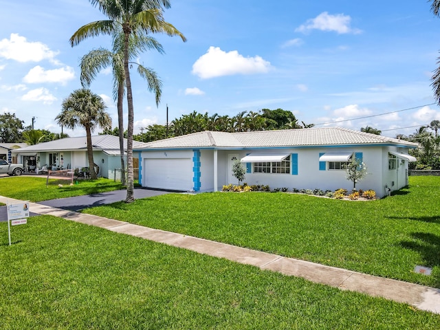 single story home with a front yard, an attached garage, driveway, and a tiled roof