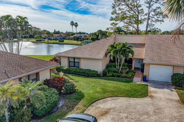 view of front of house with a front yard and a water view