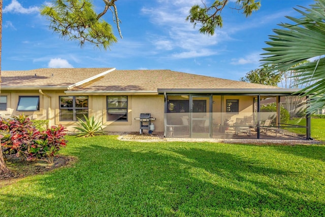 rear view of property featuring a lawn and a sunroom