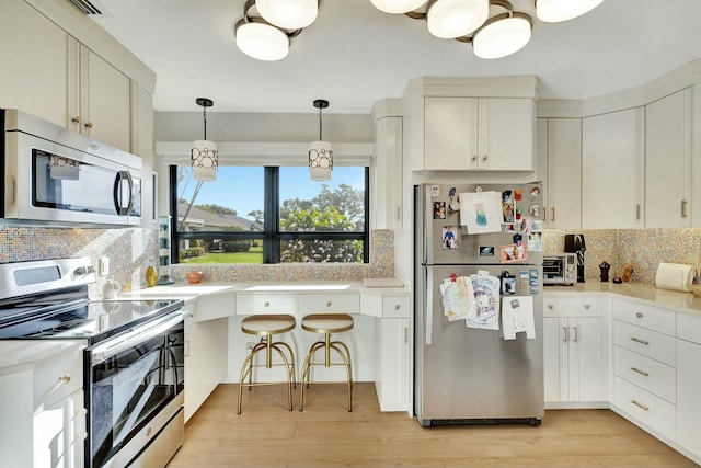 kitchen featuring white cabinets, backsplash, and stainless steel appliances