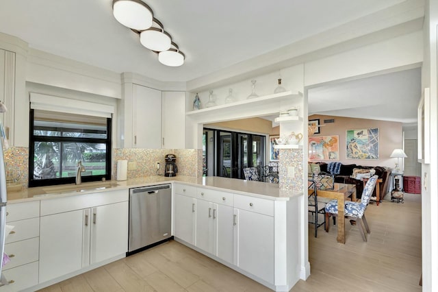 kitchen featuring dishwasher, kitchen peninsula, white cabinetry, and sink