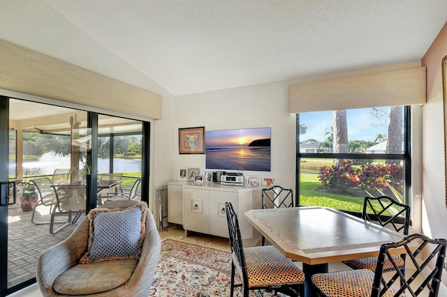 dining room featuring a textured ceiling, beverage cooler, a healthy amount of sunlight, and lofted ceiling