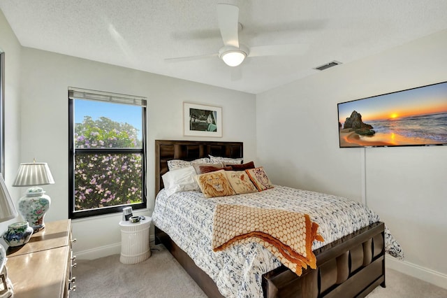 carpeted bedroom with a textured ceiling and ceiling fan