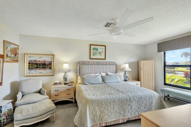 carpeted bedroom with a textured ceiling and ceiling fan