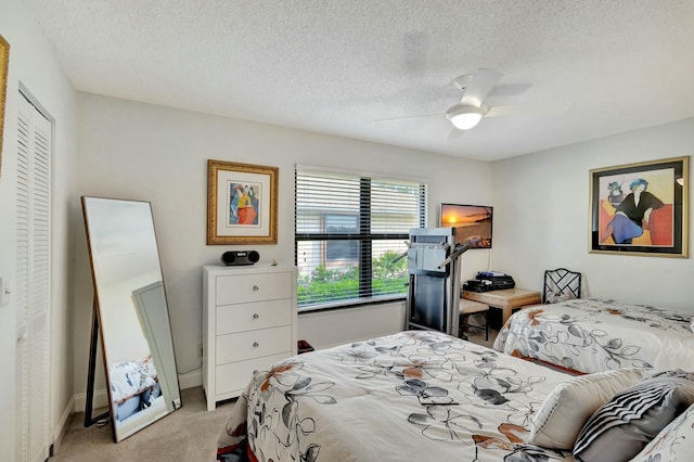 carpeted bedroom with ceiling fan, a textured ceiling, and a closet