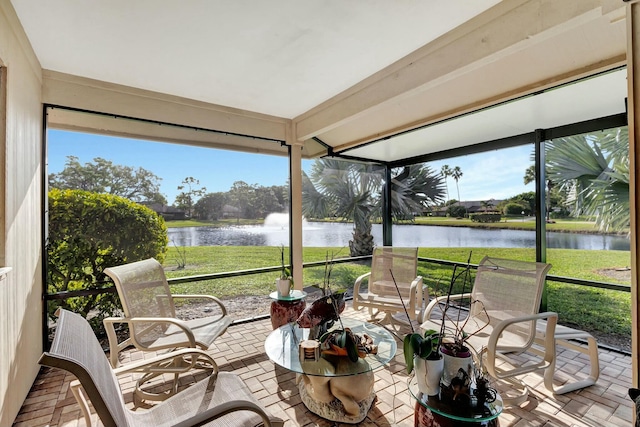 sunroom featuring a water view