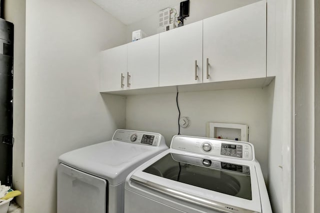 laundry room featuring cabinets and separate washer and dryer