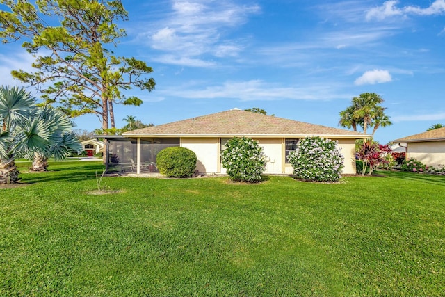 back of property with a sunroom and a yard