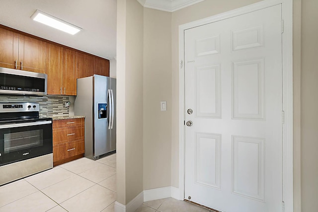 kitchen featuring stainless steel appliances, ornamental molding, light tile patterned floors, and backsplash